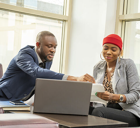 A young black businessman and woman going through some paperwork together